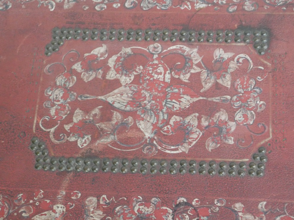 A rectangular red leather China trade trunk decorated with brass studs, brass side handles, and hand-painted gold floral motifs. View IX