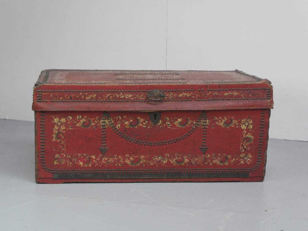 A rectangular red leather China trade trunk decorated with brass studs, brass side handles, and hand-painted gold floral motifs. View XII