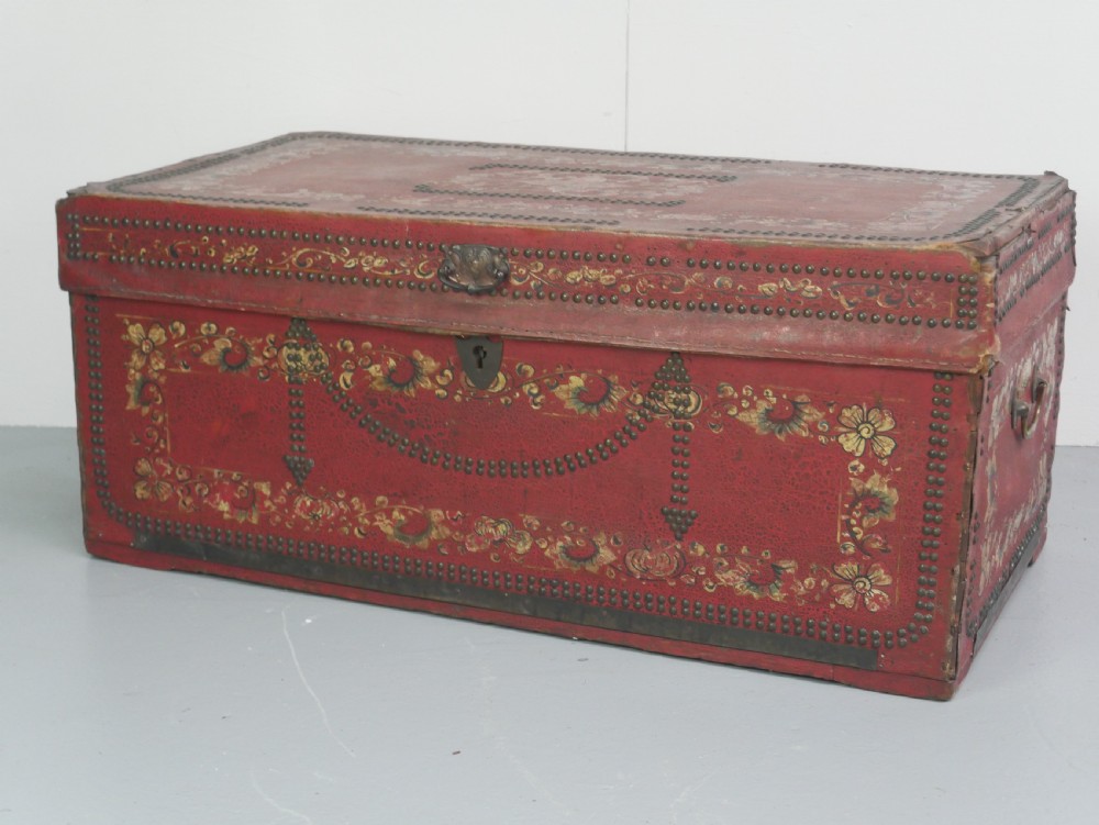A rectangular red leather China trade trunk decorated with brass studs, brass side handles, and hand-painted gold floral motifs. View XIII
