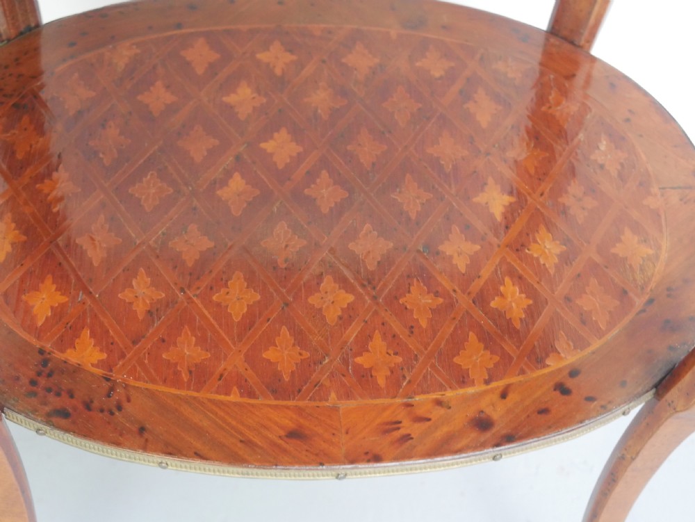 An oval Louis XV style wooden centre table featuring geometric parquetry inlay, a single drawer, a lower tier, cabriole legs, and ornate gilt metal mounts. View IV