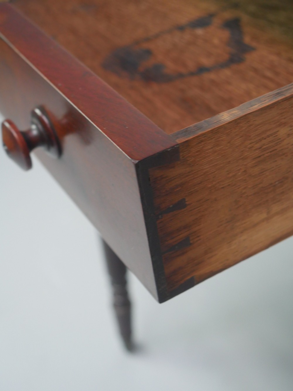 A dark mahogany Regency side table featuring a single drawer with turned knobs, a central brass keyhole, and turned legs terminating in castors. View XI