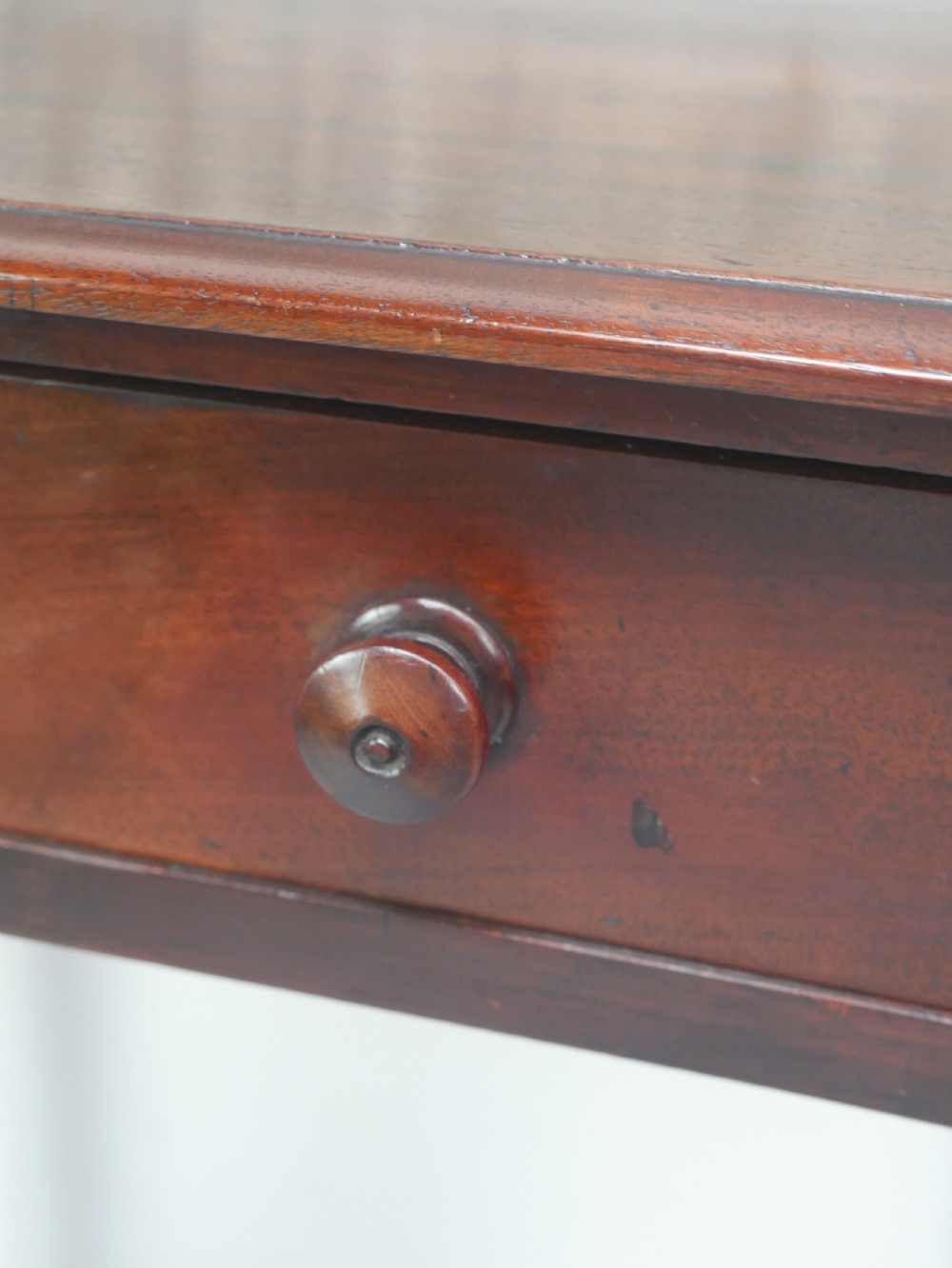 A dark mahogany Regency side table featuring a single drawer with turned knobs, a central brass keyhole, and turned legs terminating in castors. View XII