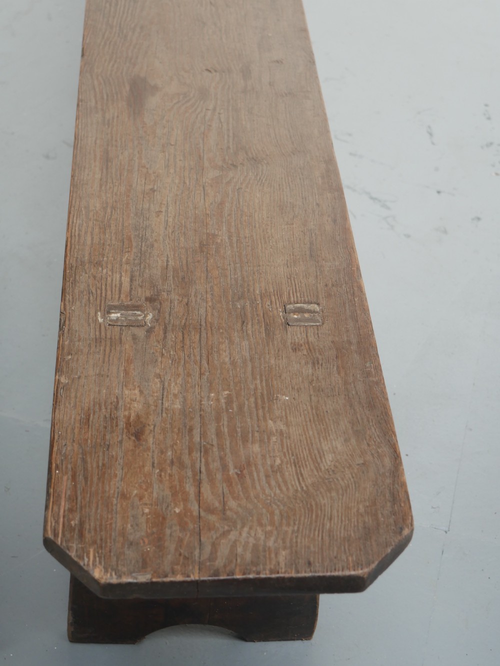 A pair of long, dark brown rustic pine benches featuring solid plank tops and trestle-style slab legs with arched cutouts. View II