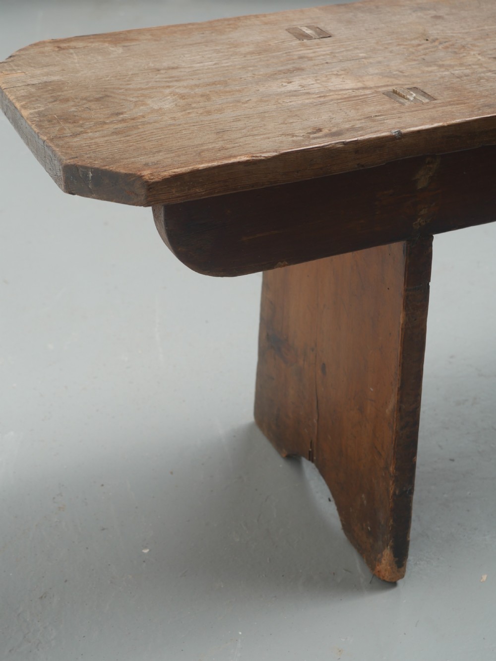 A pair of long, dark brown rustic pine benches featuring solid plank tops and trestle-style slab legs with arched cutouts. View VI