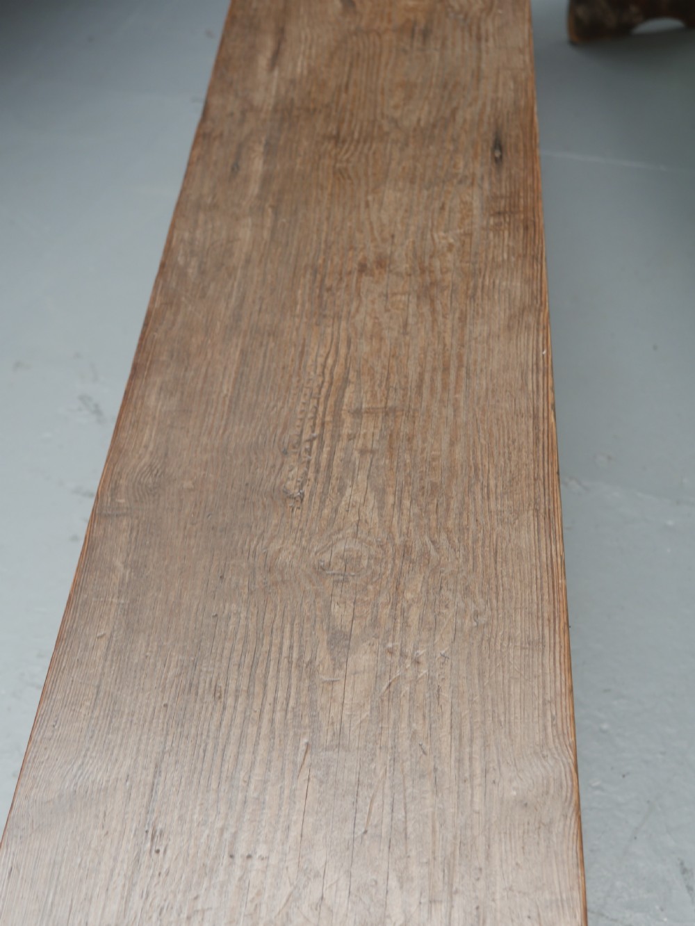 A pair of long, dark brown rustic pine benches featuring solid plank tops and trestle-style slab legs with arched cutouts. View VII