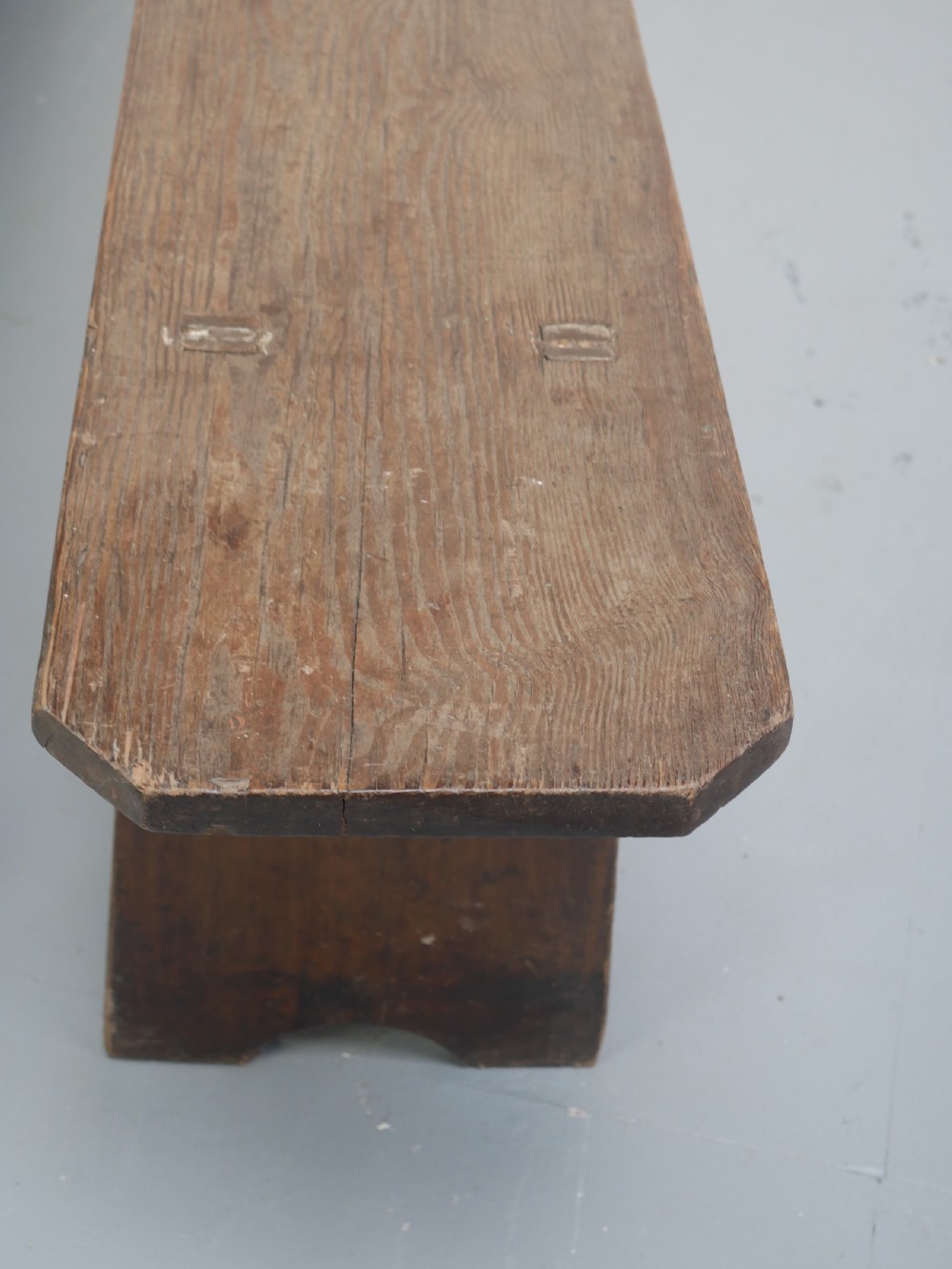 A pair of long, dark brown rustic pine benches featuring solid plank tops and trestle-style slab legs with arched cutouts. View IX