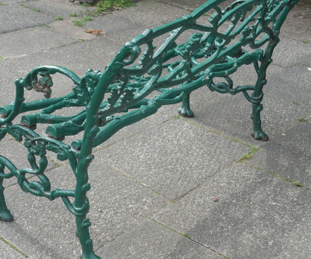 A green painted Victorian cast iron garden bench featuring a naturalistic organic branch and twig pattern. View IV