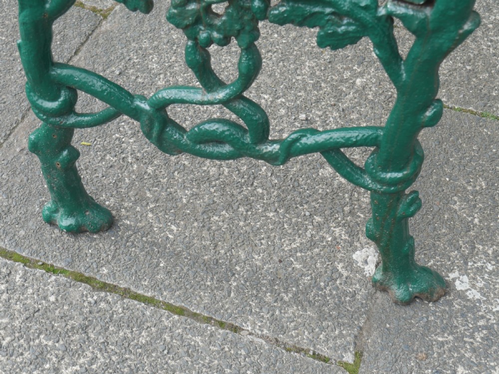 A green painted Victorian cast iron garden bench featuring a naturalistic organic branch and twig pattern. View V