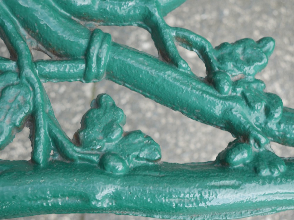 A green painted Victorian cast iron garden bench featuring a naturalistic organic branch and twig pattern. View VIII