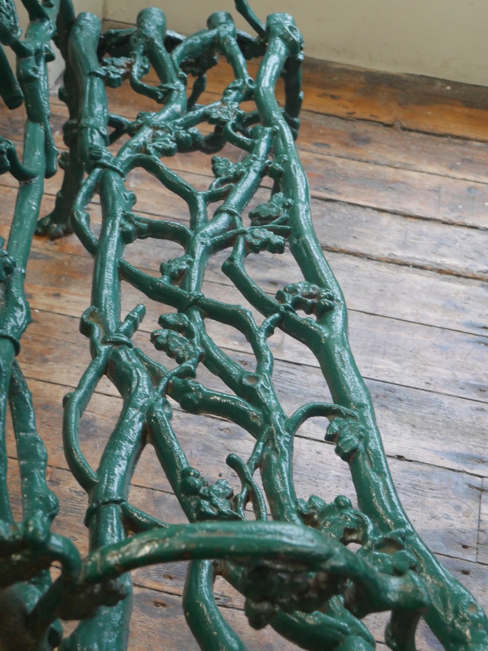 A green painted Victorian cast iron garden bench featuring a naturalistic organic branch and twig pattern. View XI
