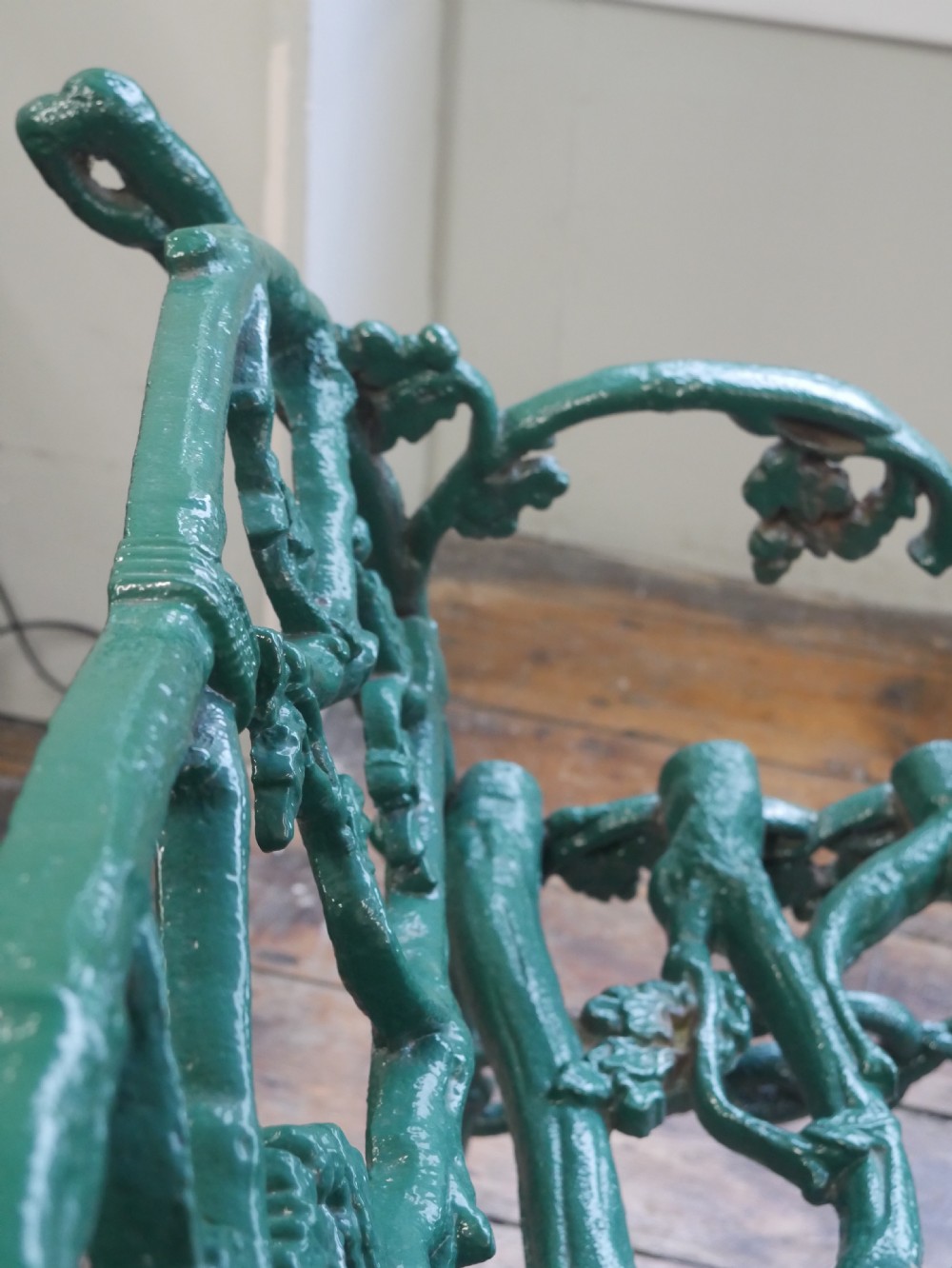 A green painted Victorian cast iron garden bench featuring a naturalistic organic branch and twig pattern. View XIII