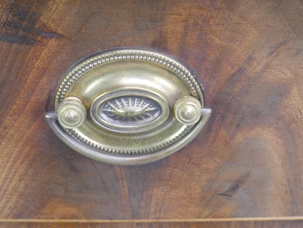 A small Georgian bowfront mahogany sideboard featuring an arched central apron, two side drawers with oval brass handles, and square tapered legs. View XIII