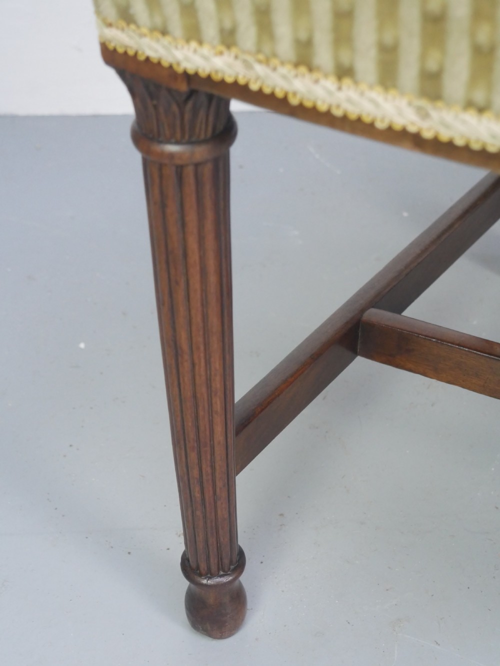 A pair of antique Georgian mahogany side chairs featuring pierced urn carved splats, arched backs, and upholstered seats supported by fluted front legs. View IX