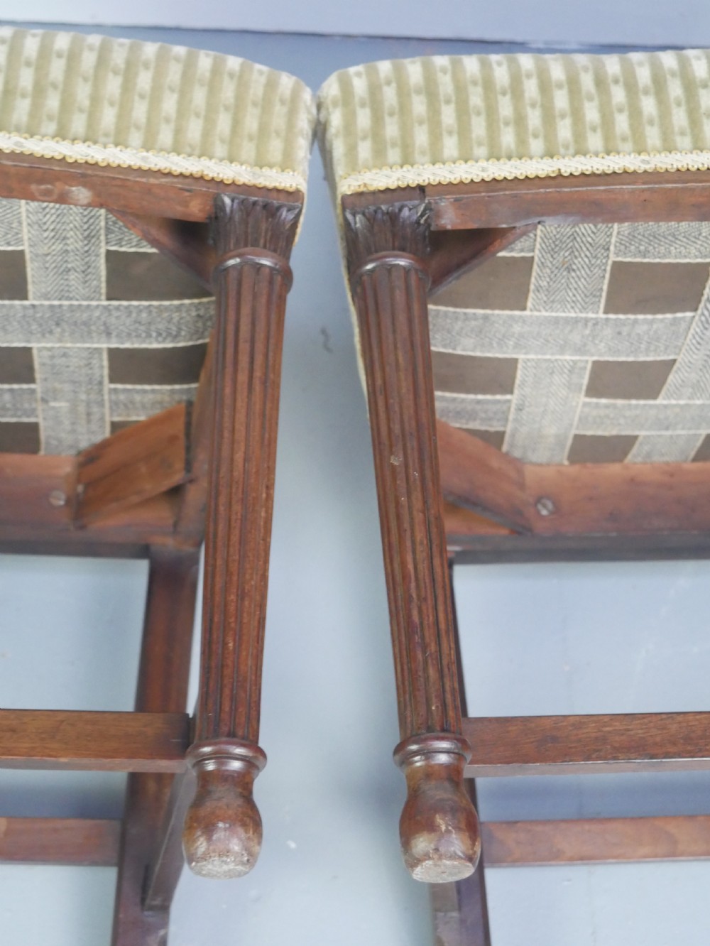 A pair of antique Georgian mahogany side chairs featuring pierced urn carved splats, arched backs, and upholstered seats supported by fluted front legs. View XXII
