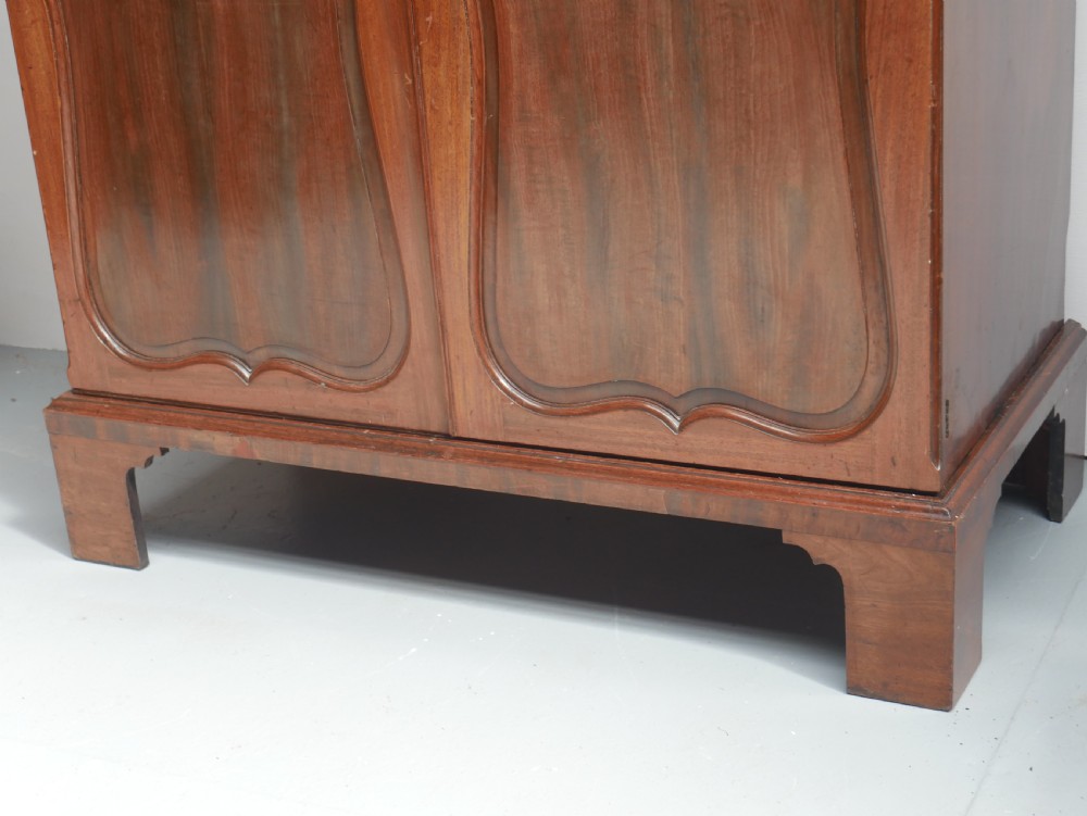 A Georgian mahogany double-door hanging wardrobe featuring shaped curvilinear door panels and sturdy bracket feet. View XI