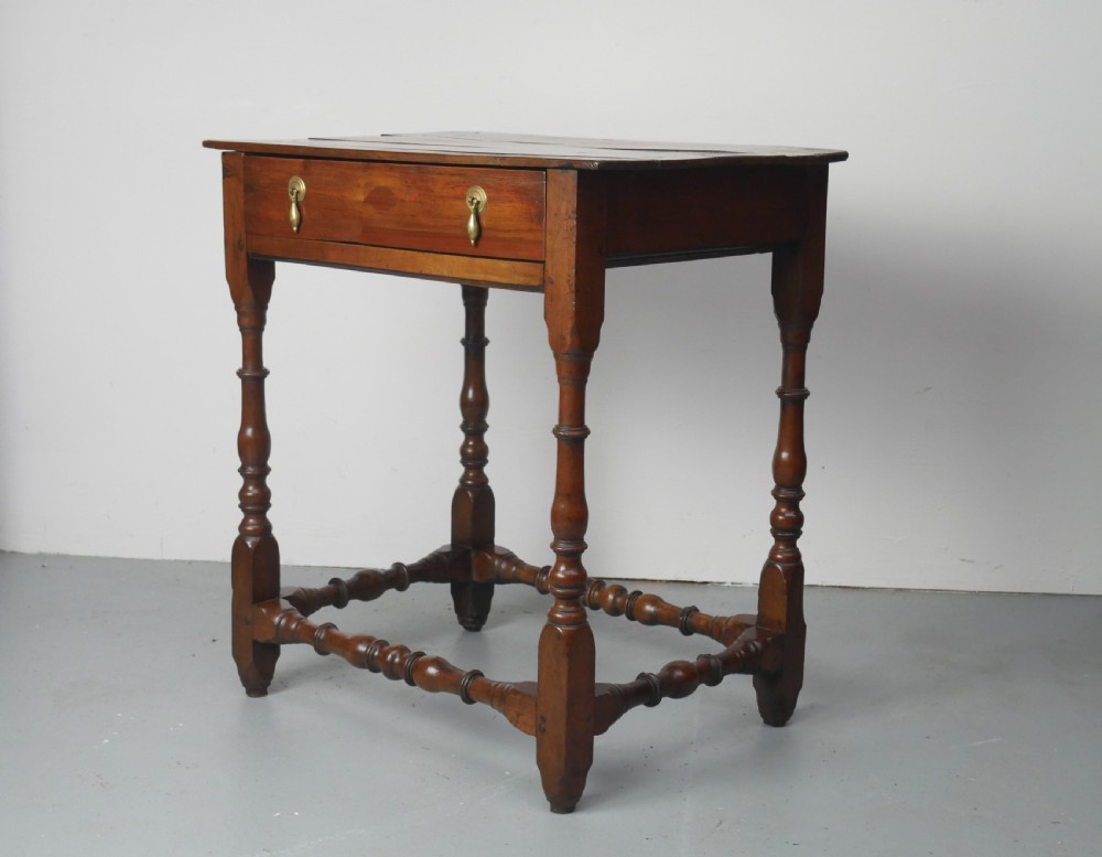 An 18th-century fruitwood side table featuring a single drawer with two brass teardrop handles, slender turned legs, and lower connecting stretchers. View II