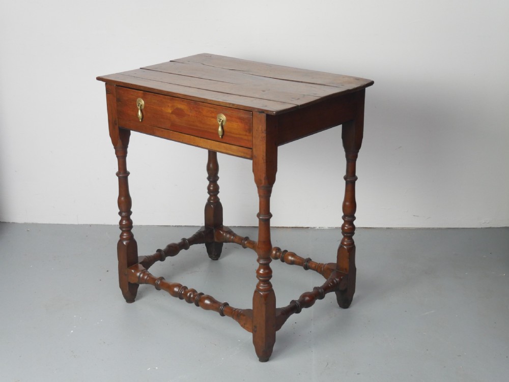 An 18th-century fruitwood side table featuring a single drawer with two brass teardrop handles, slender turned legs, and lower connecting stretchers. View III
