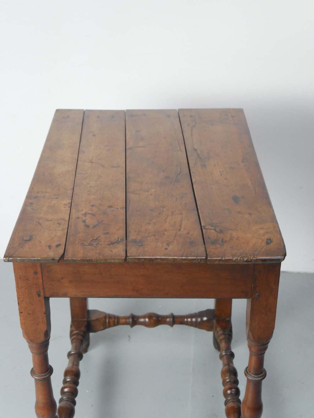 An 18th-century fruitwood side table featuring a single drawer with two brass teardrop handles, slender turned legs, and lower connecting stretchers. View IV