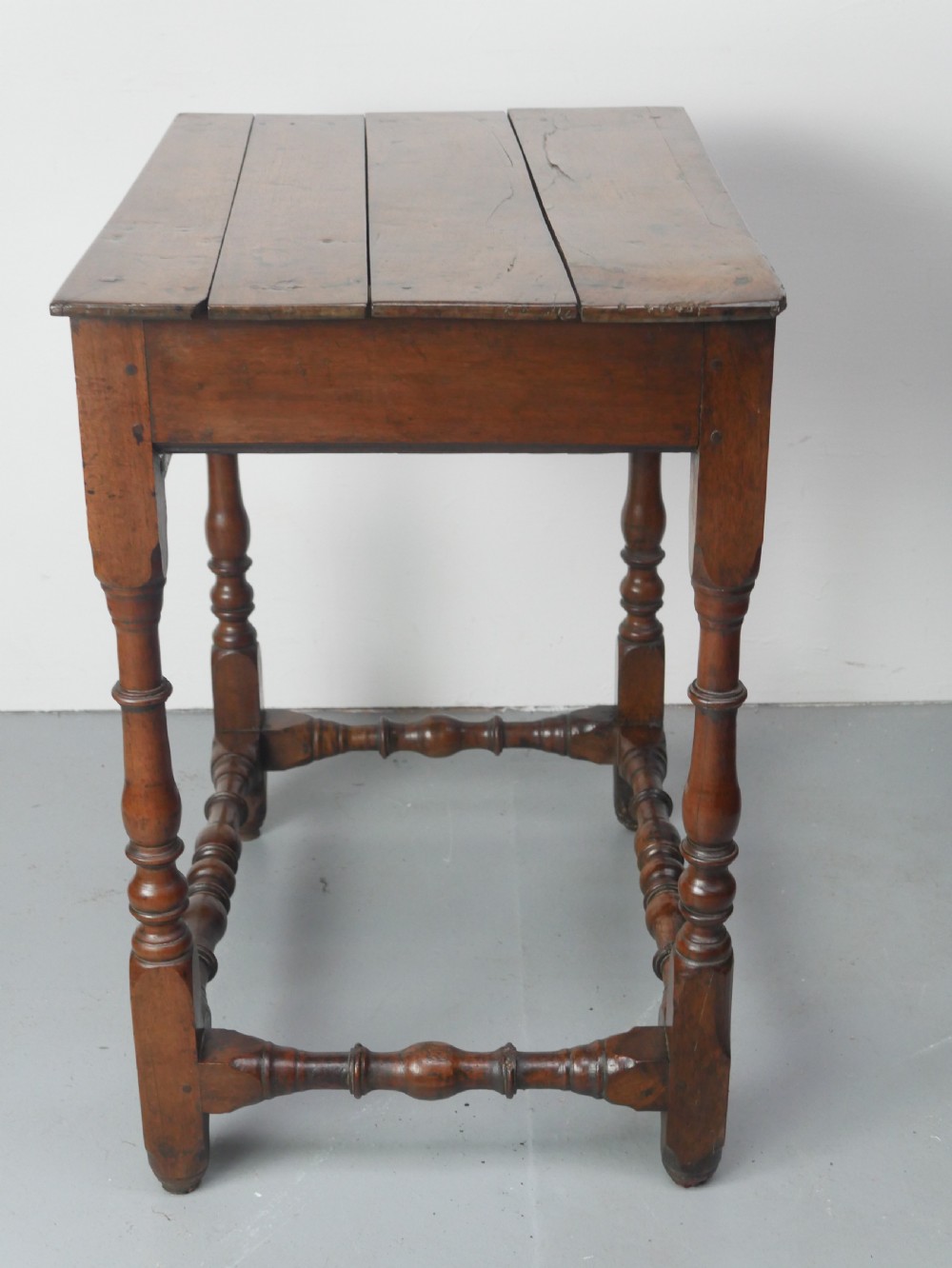An 18th-century fruitwood side table featuring a single drawer with two brass teardrop handles, slender turned legs, and lower connecting stretchers. View VIII