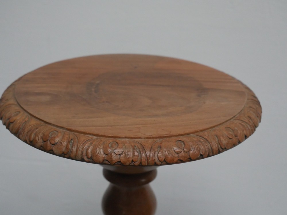 A tall walnut plant stand featuring a carved circular top, turned central column, and tripod base with cabriole legs. View III