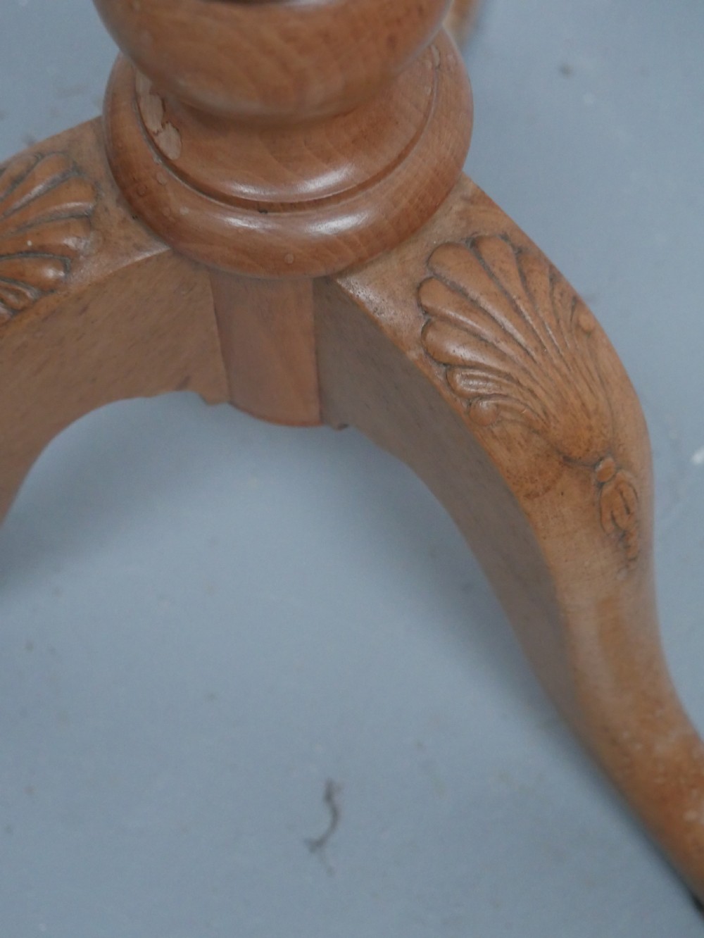 A tall walnut plant stand featuring a carved circular top, turned central column, and tripod base with cabriole legs. View V