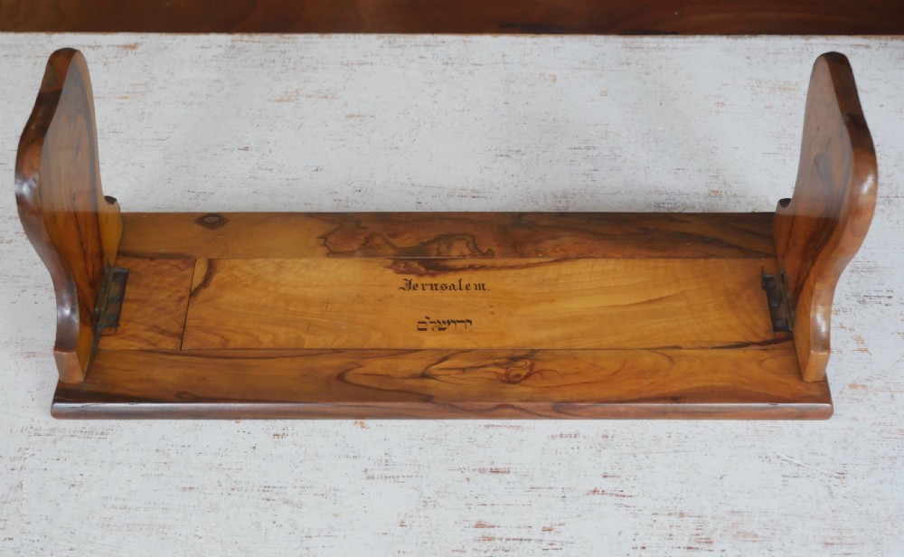 An olive wood extending book slide with hinged rounded ends and black printed text reading Jerusalem in English and Hebrew script.
