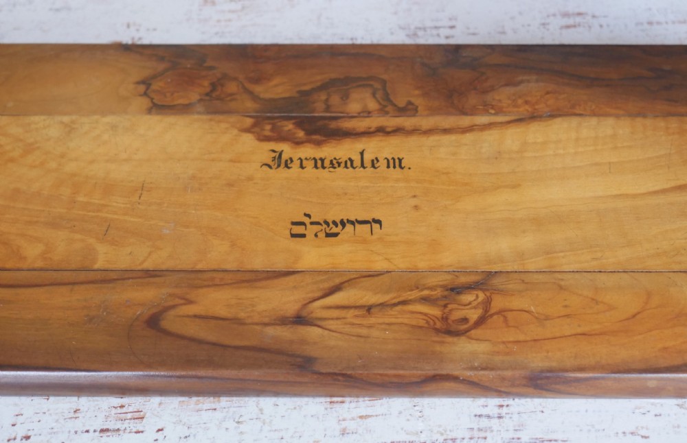 An olive wood extending book slide with hinged rounded ends and black printed text reading Jerusalem in English and Hebrew script. View VIII