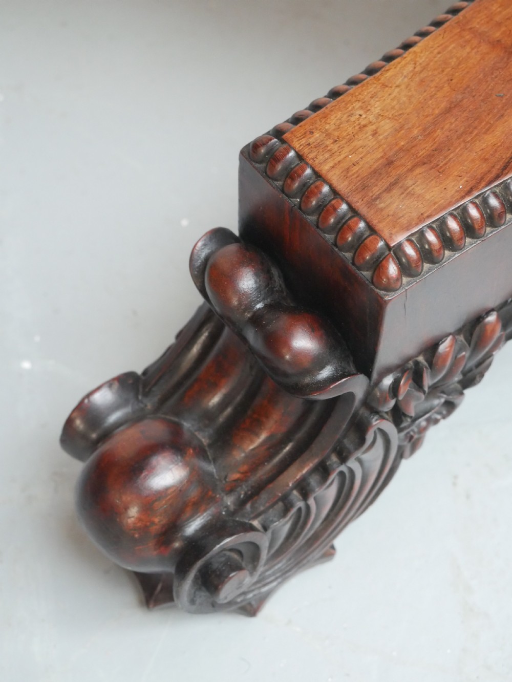 A Regency mahogany circular centre table featuring a beaded moulding edge, a carved gadrooned pedestal, and a triform base with scrolled feet. View III