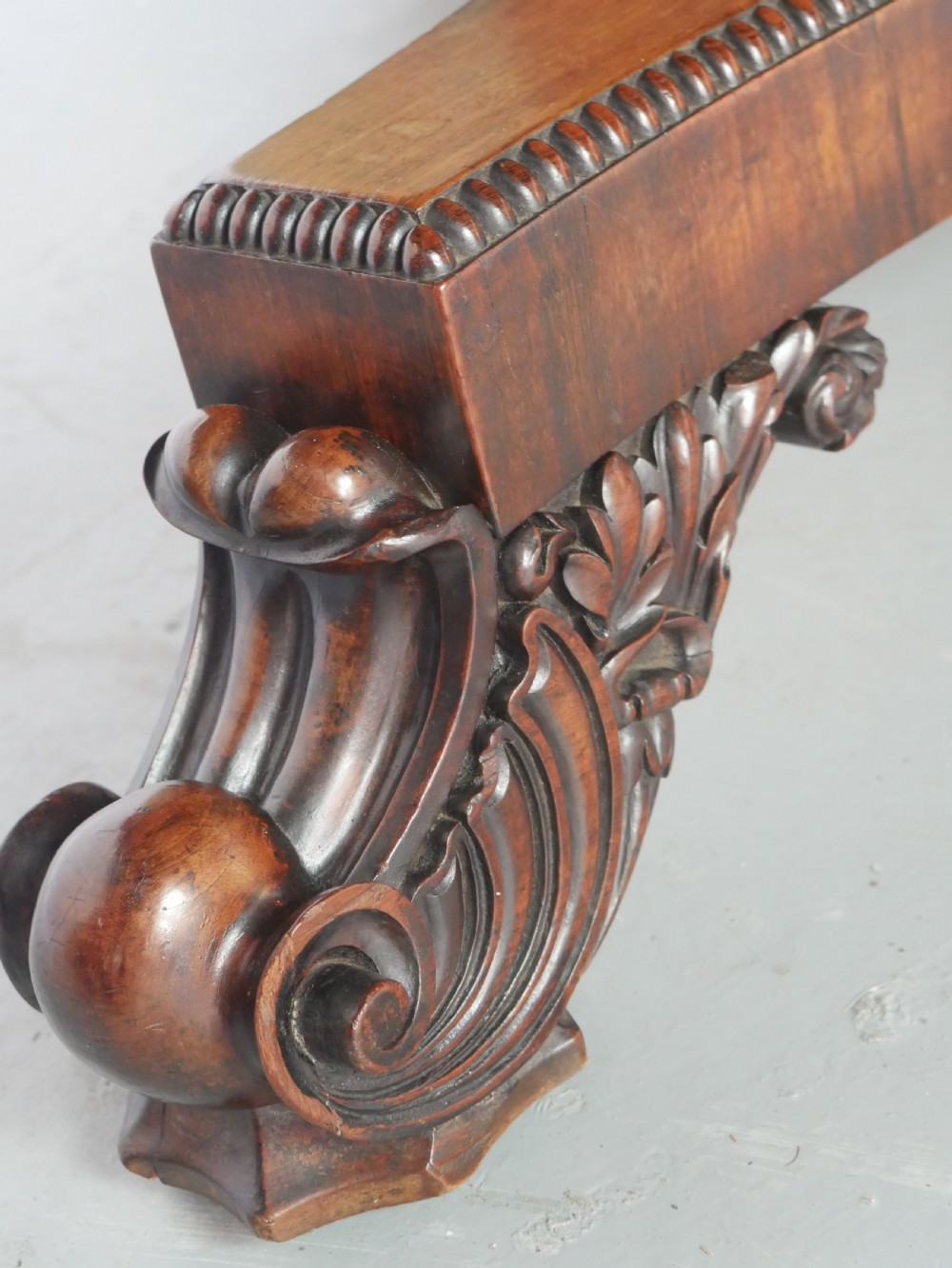 A Regency mahogany circular centre table featuring a beaded moulding edge, a carved gadrooned pedestal, and a triform base with scrolled feet. View IX