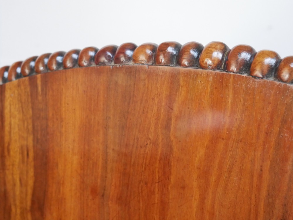 A Regency mahogany circular centre table featuring a beaded moulding edge, a carved gadrooned pedestal, and a triform base with scrolled feet. View XV
