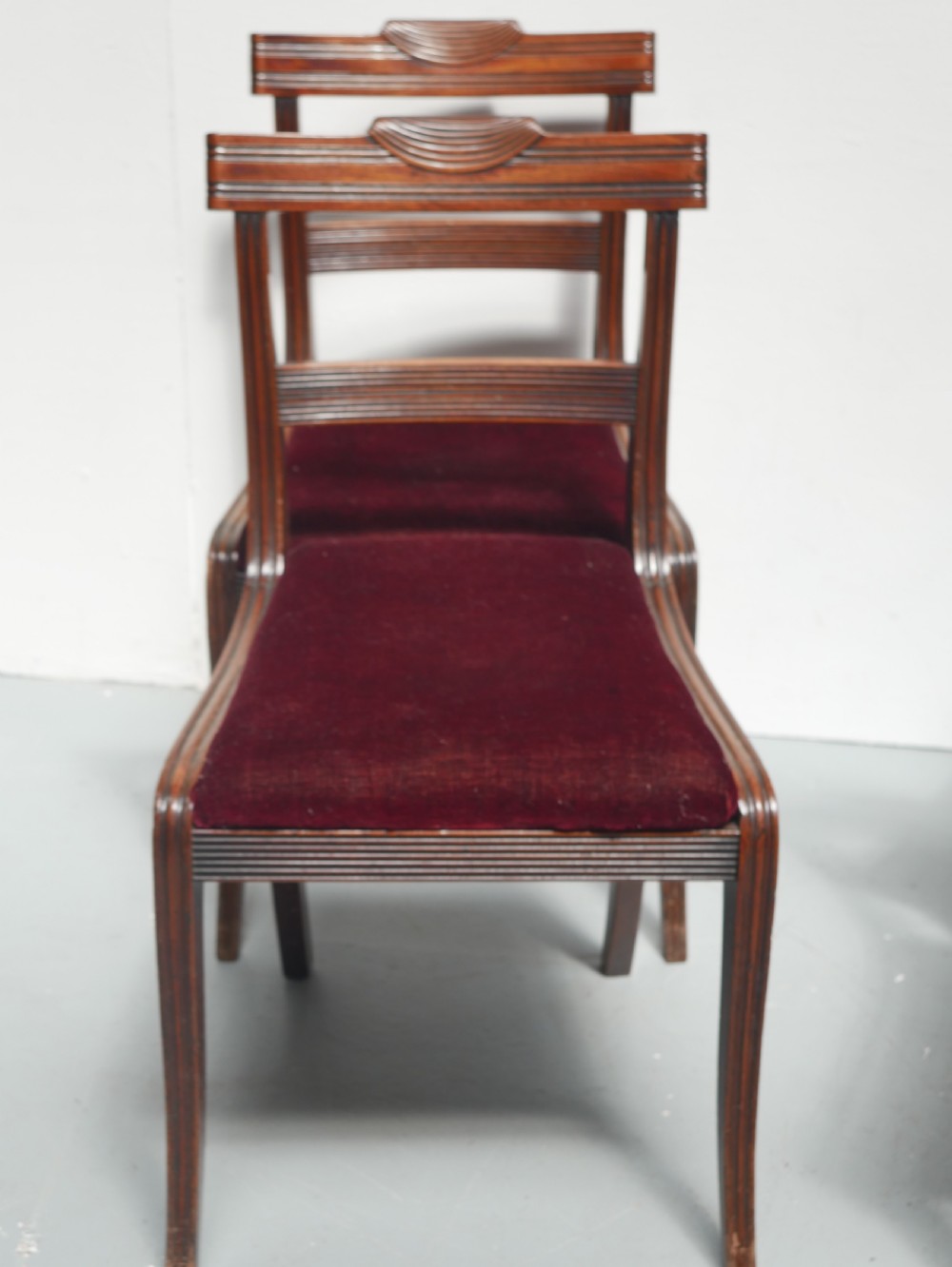 Set of four Regency mahogany dining chairs featuring carved crest rails, horizontal crossbars, and padded seats. View III