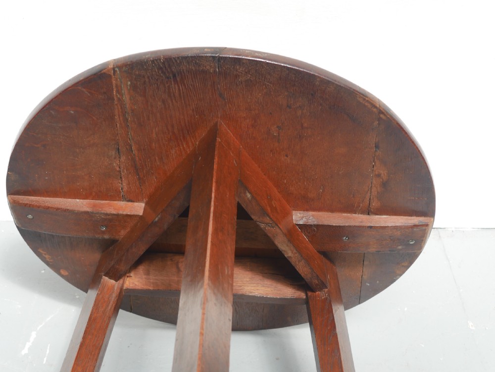 A dark Georgian oak cricket table featuring a circular plank top, three tapered legs, and a lower triangular shelf. View VIII