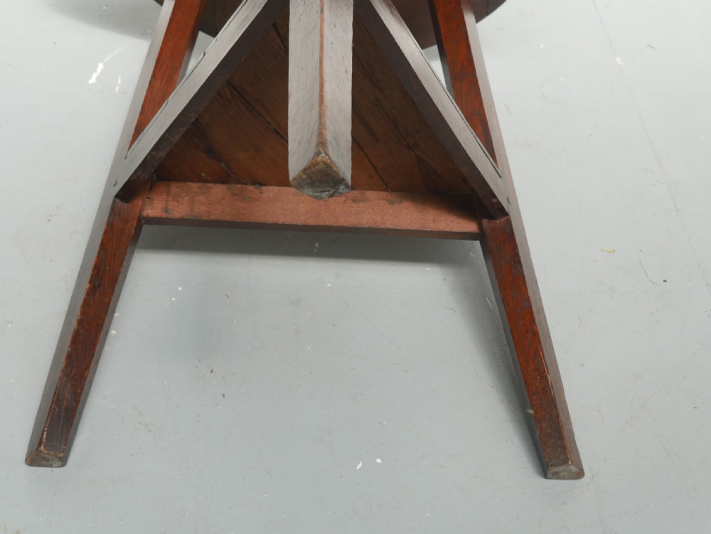A dark Georgian oak cricket table featuring a circular plank top, three tapered legs, and a lower triangular shelf. View IX