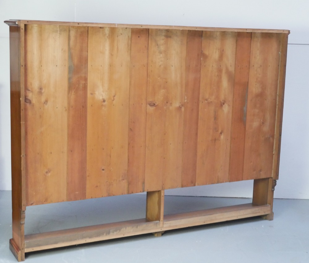 A large double-bay open oak bookcase with horizontal shelves filled with antique leather-bound books. View IX