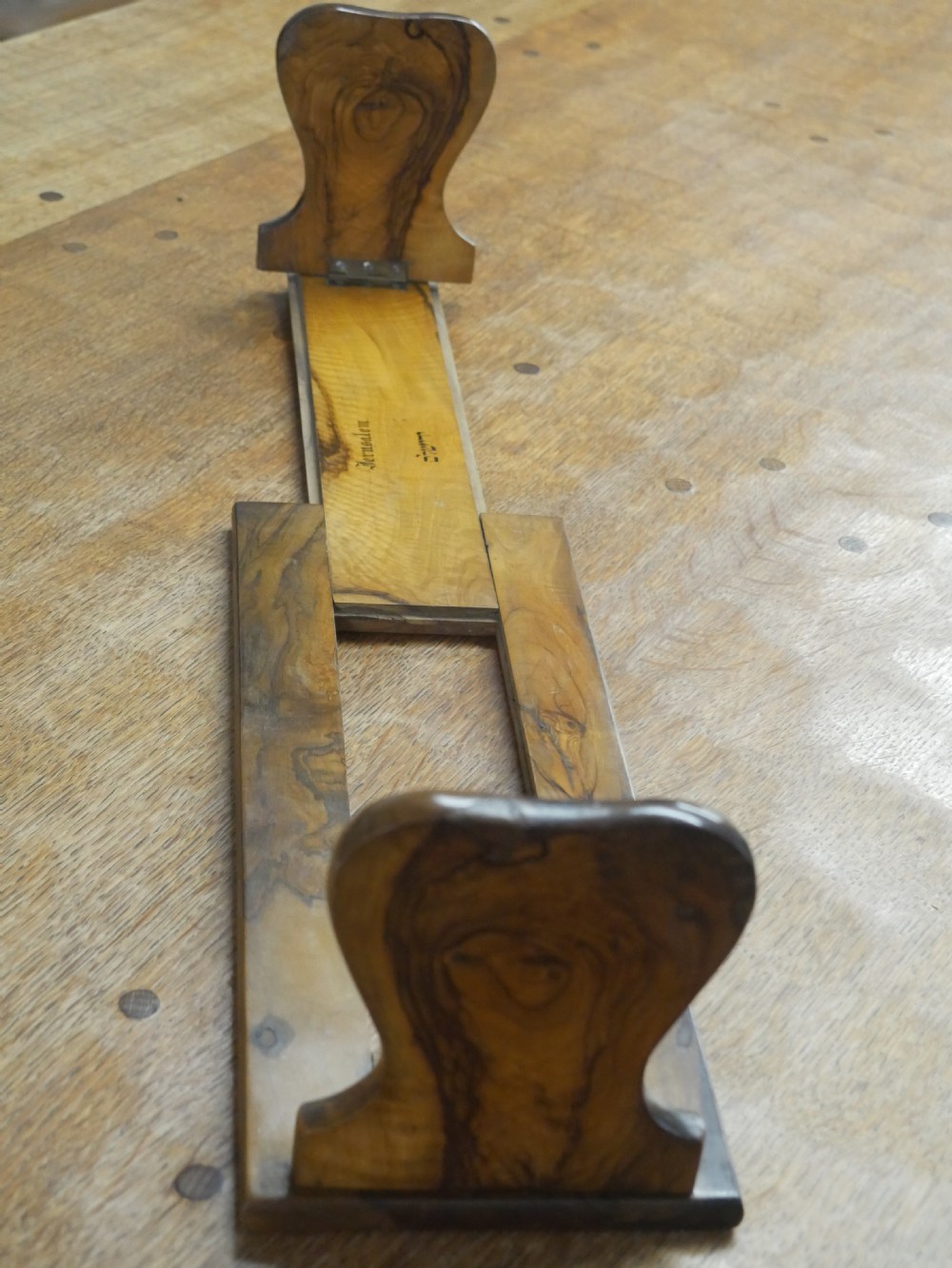 An olive wood extending book slide with hinged rounded ends and black printed text reading Jerusalem in English and Hebrew script. View IX