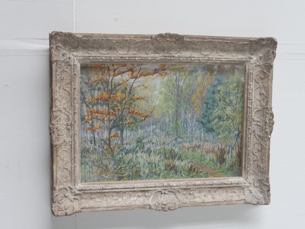 An antique pastel painting depicting an autumn woodland landscape, presented within a carved off-white frame. View II