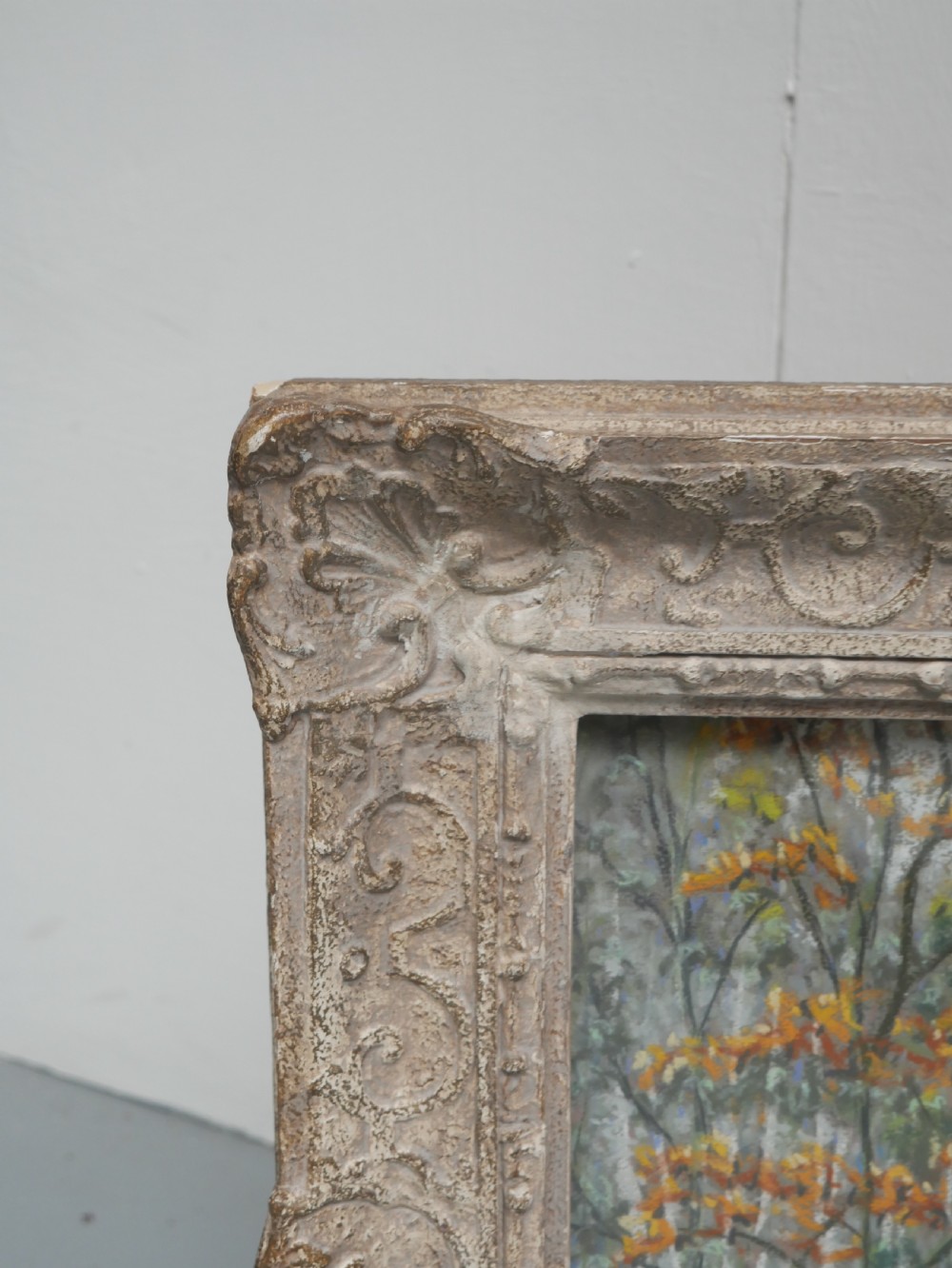 An antique pastel painting depicting an autumn woodland landscape, presented within a carved off-white frame. View VII
