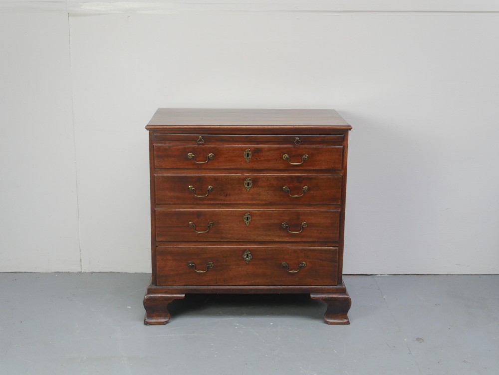 A Georgian mahogany small chest of drawers featuring four graduated drawers, brass swan-neck drop handles, keyhole escutcheons, and shaped bracket feet. View II