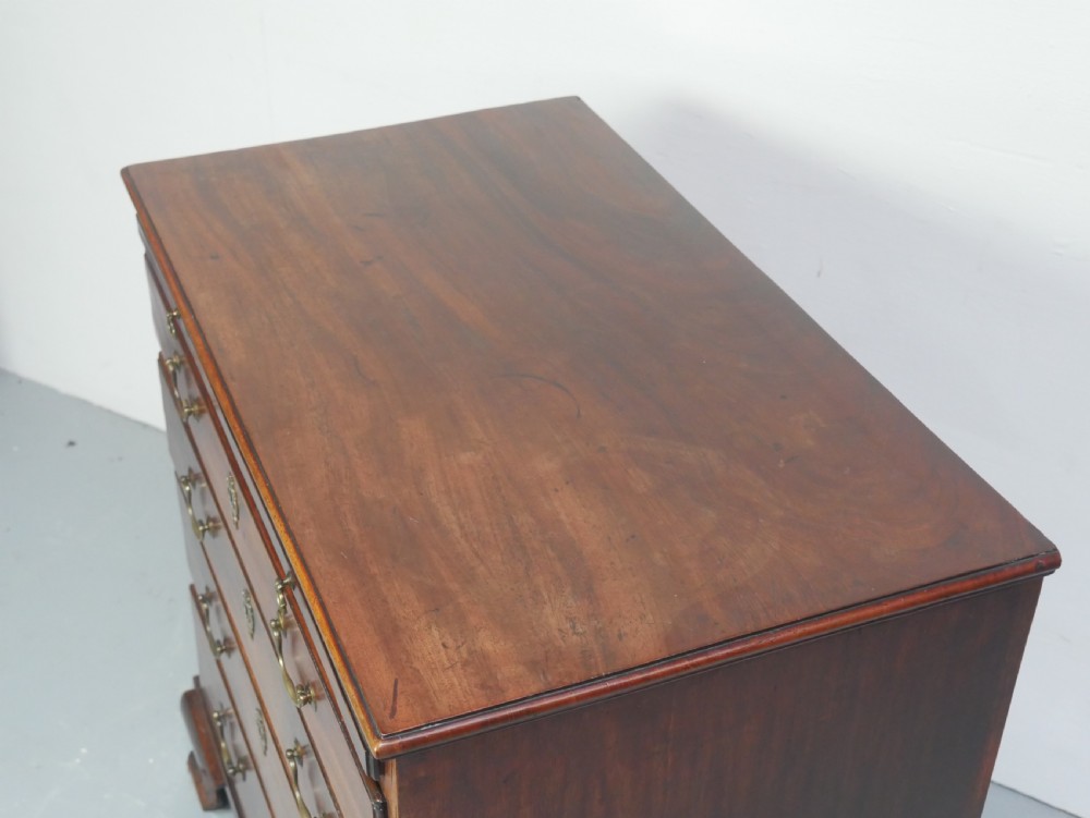 A Georgian mahogany small chest of drawers featuring four graduated drawers, brass swan-neck drop handles, keyhole escutcheons, and shaped bracket feet. View III