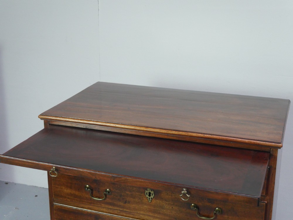 A Georgian mahogany small chest of drawers featuring four graduated drawers, brass swan-neck drop handles, keyhole escutcheons, and shaped bracket feet. View IX