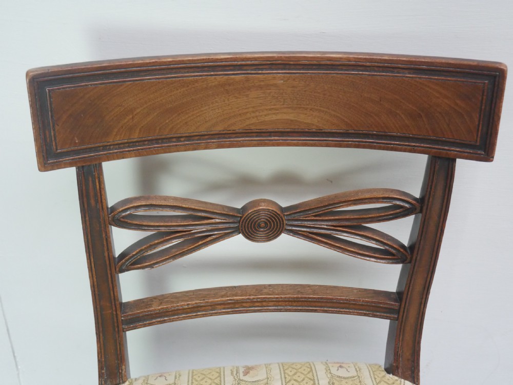 A set of four Scottish Georgian mahogany dining chairs featuring carved bow splats, square legs with stretchers, and green and cream patterned upholstery. View II