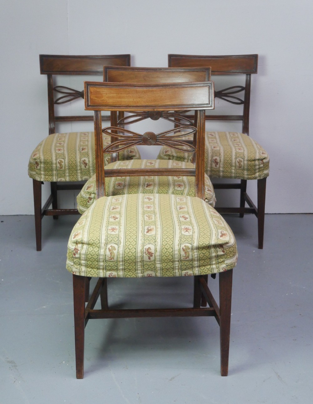 A set of four Scottish Georgian mahogany dining chairs featuring carved bow splats, square legs with stretchers, and green and cream patterned upholstery. View VII