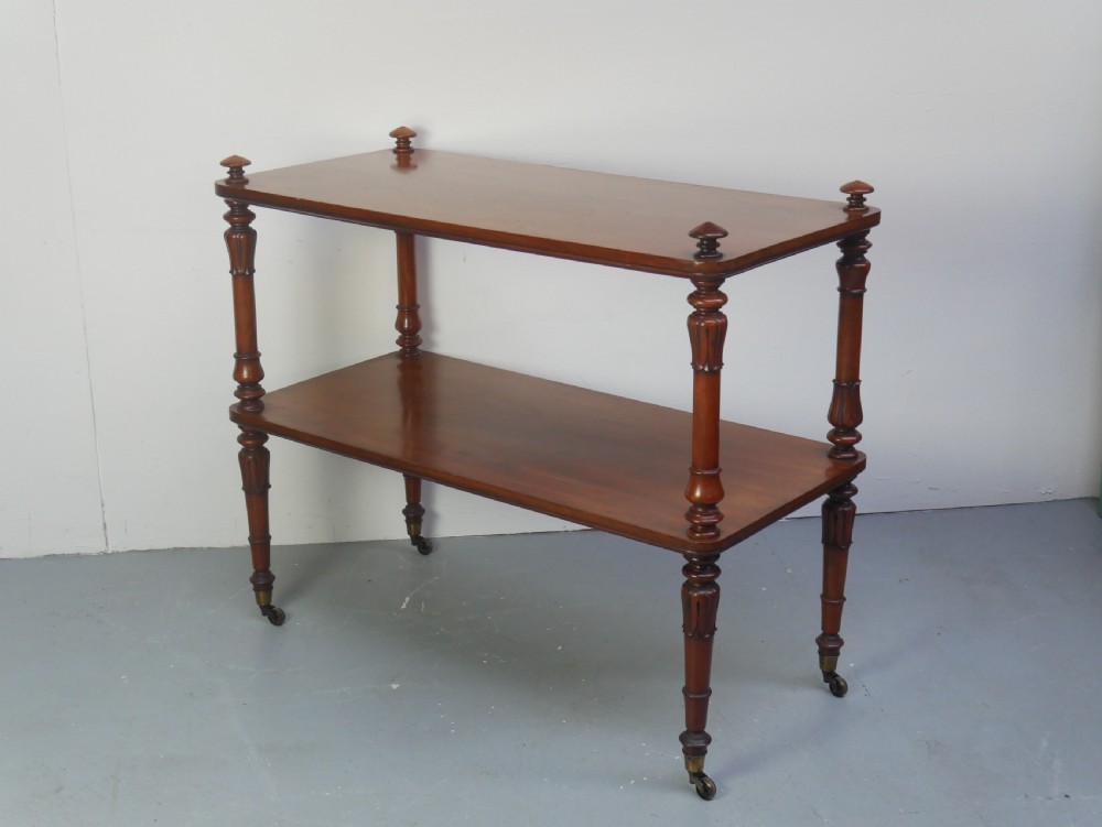 A 19th-century mahogany two-tier buffet table featuring turned support columns, corner finials, and brass castors. View II