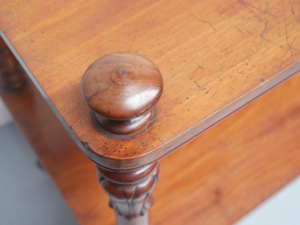 A 19th-century mahogany two-tier buffet table featuring turned support columns, corner finials, and brass castors. View VI