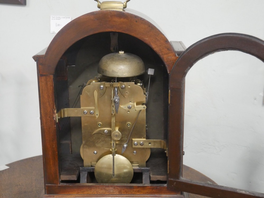 A Georgian mahogany bracket clock featuring an arched top with a brass handle, white dial with Roman numerals, and strike silent sub-dial. View III