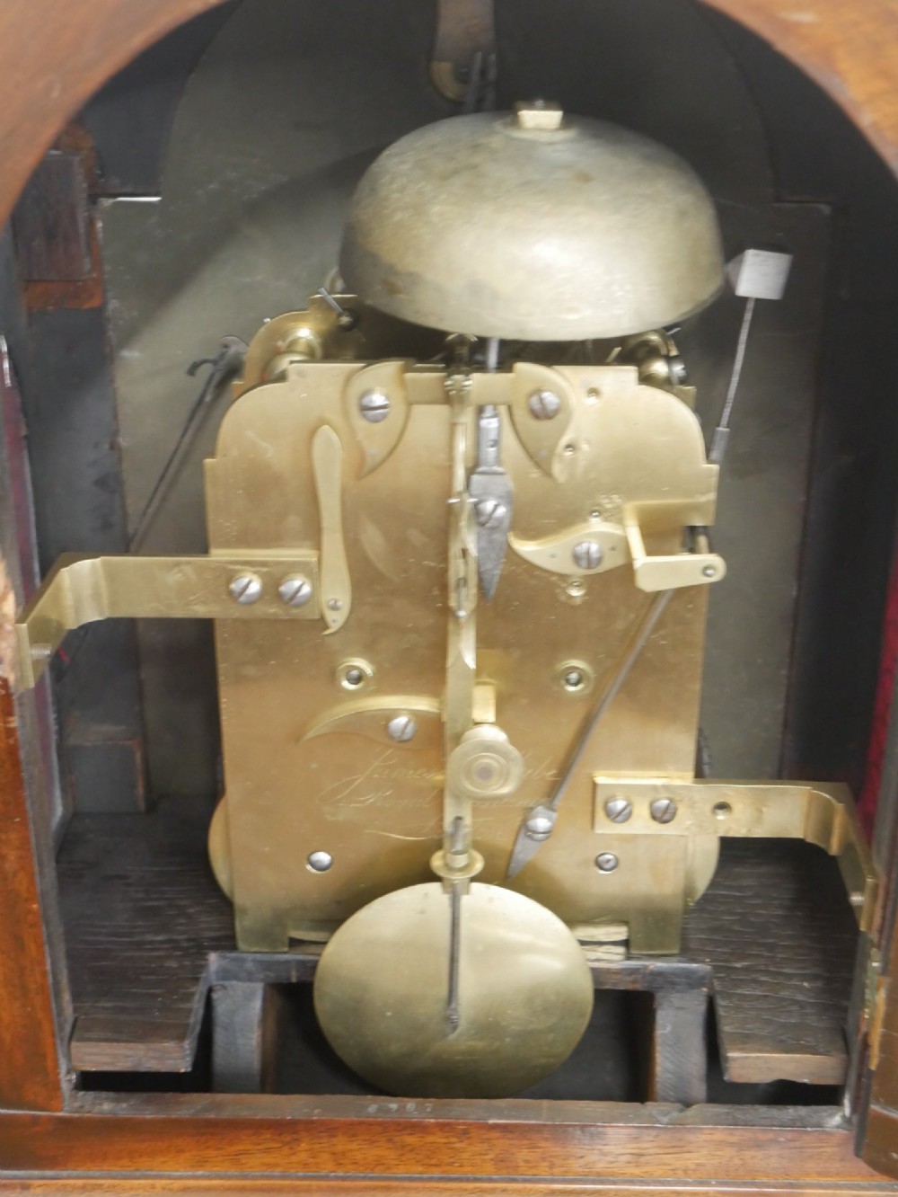 A Georgian mahogany bracket clock featuring an arched top with a brass handle, white dial with Roman numerals, and strike silent sub-dial. View IV