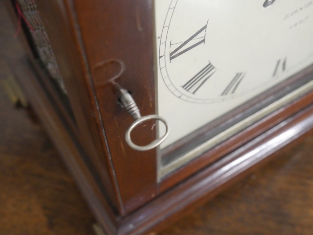 A Georgian mahogany bracket clock featuring an arched top with a brass handle, white dial with Roman numerals, and strike silent sub-dial. View VIII