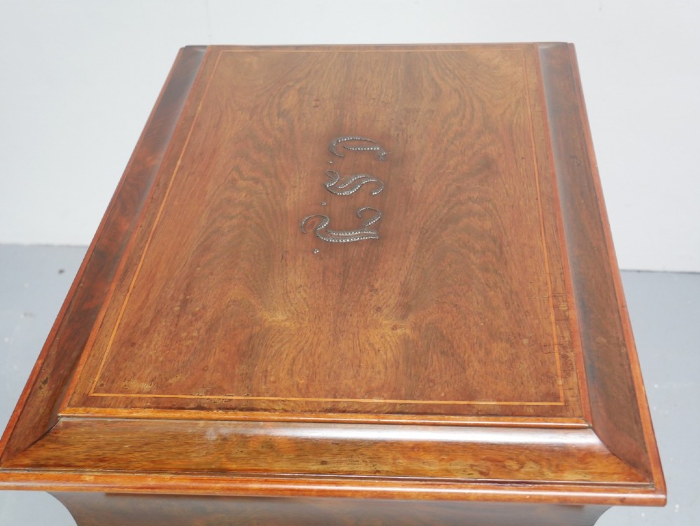 An antique French rosewood box with inlaid monogram resting on a matching stand with curved legs and brass castors. View III