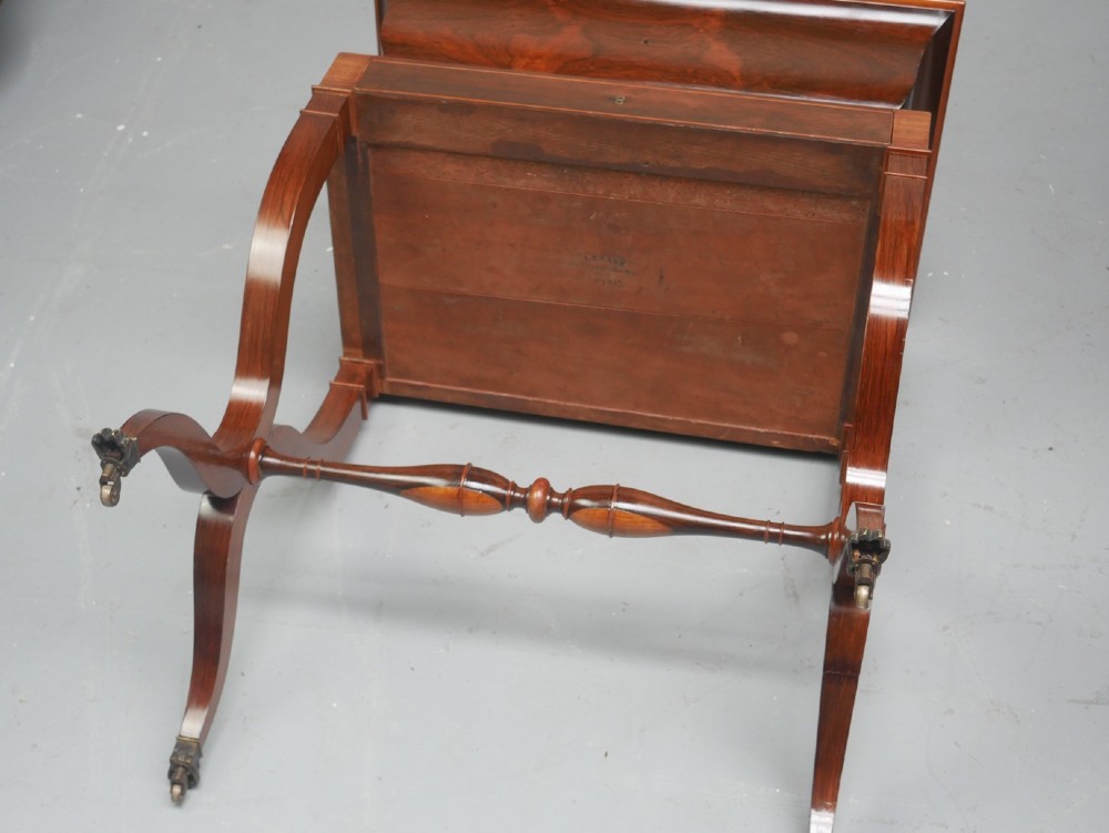 An antique French rosewood box with inlaid monogram resting on a matching stand with curved legs and brass castors. View X