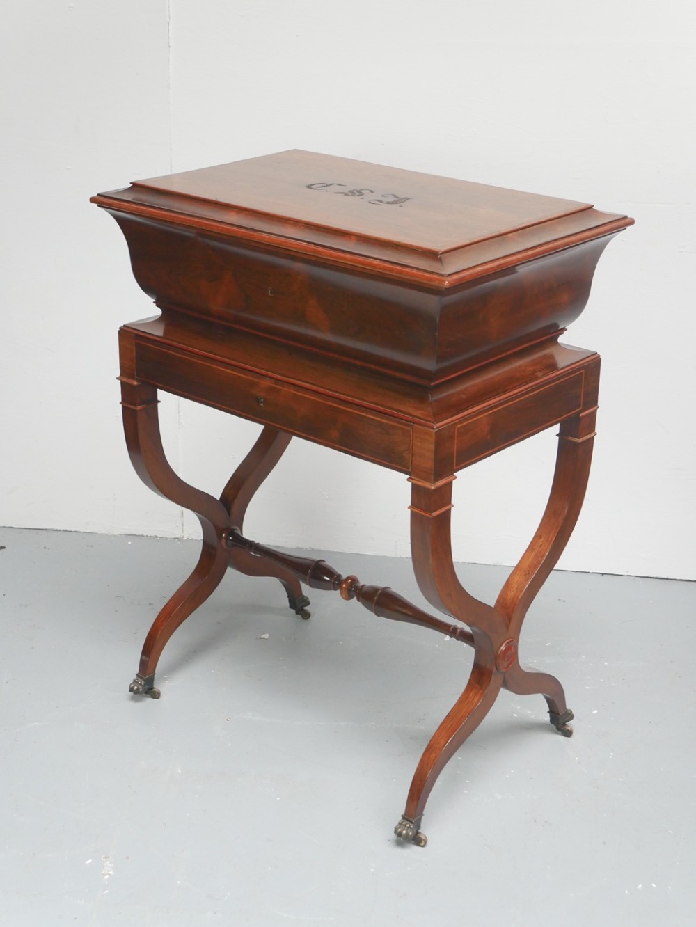 An antique French rosewood box with inlaid monogram resting on a matching stand with curved legs and brass castors. View XII